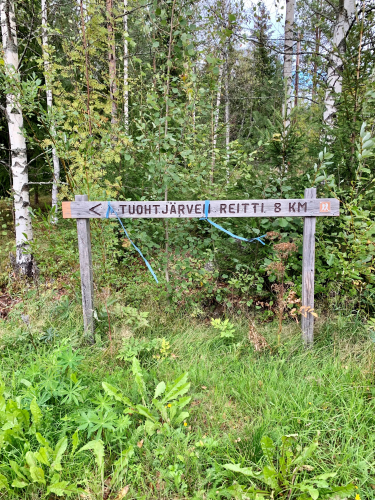 Tuohtjärven reitti 8 km -kyltti kuvattuna metsässä.